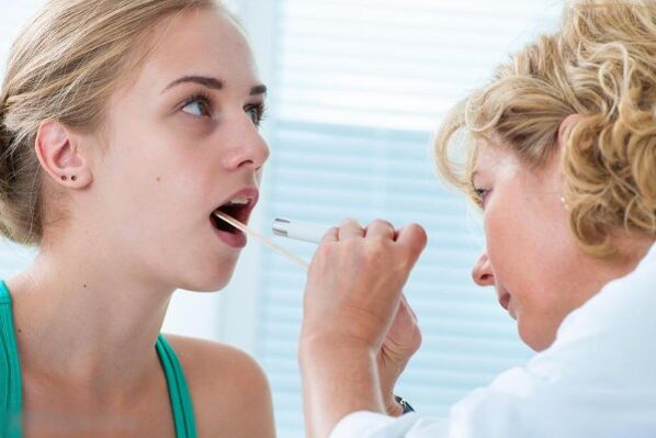 Ārsts pārbauda mutes dobumu, lai noteiktu papilomu klātbūtni